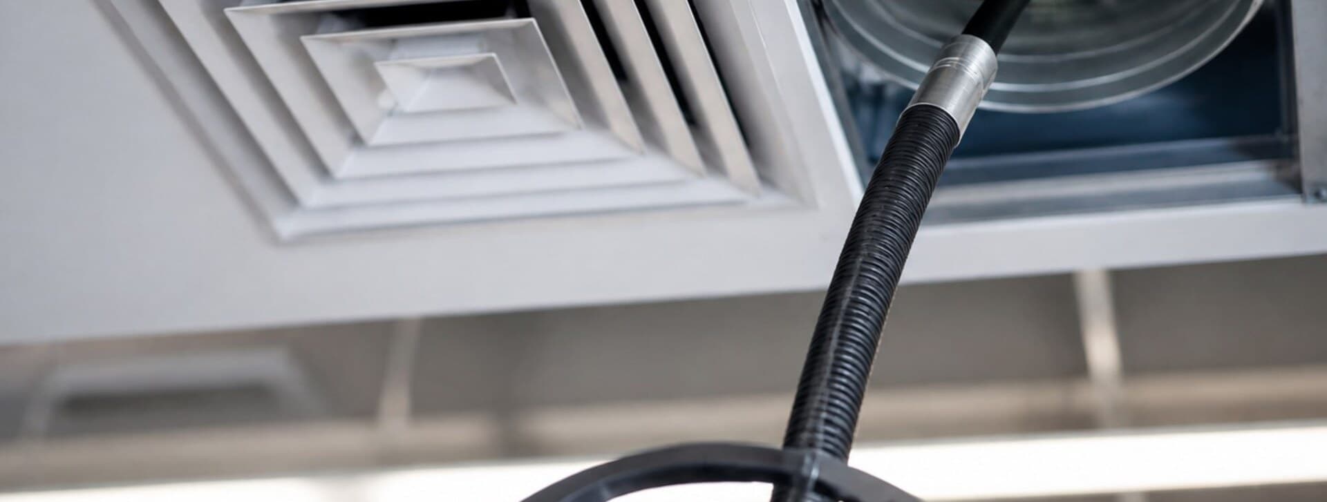 Boyau d'aspiration raccordé à une bouche de ventilation au plafond